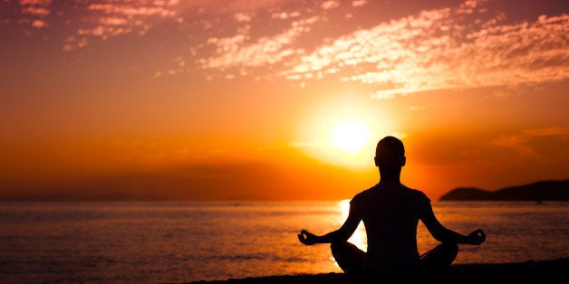 woman doing yoga at sunset