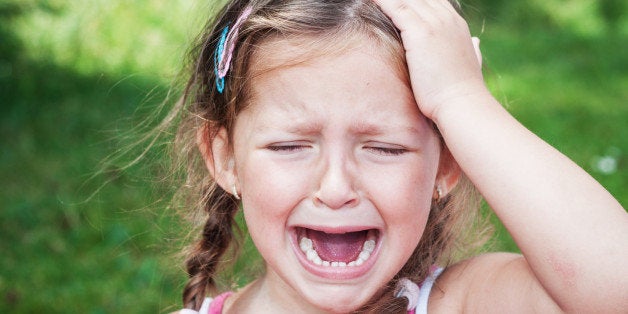 young girl crying because of headache