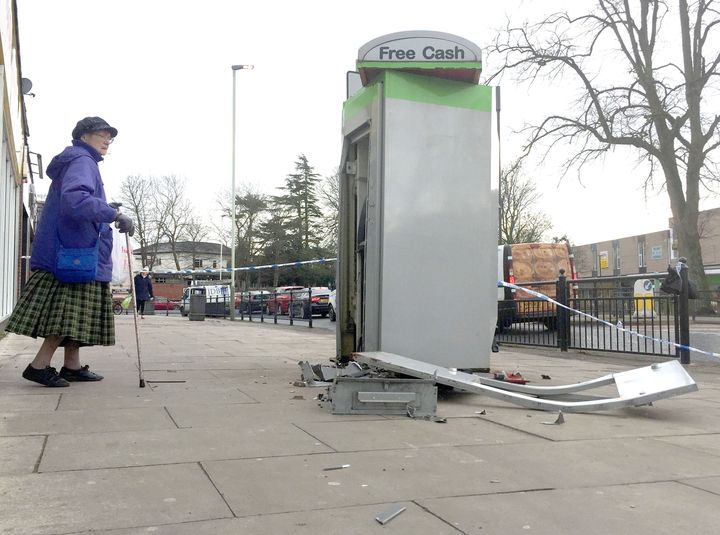 A woman walks past the scene outside Heron Foods on Cockerton Green, Darlington, after thieves blew up a cash machine