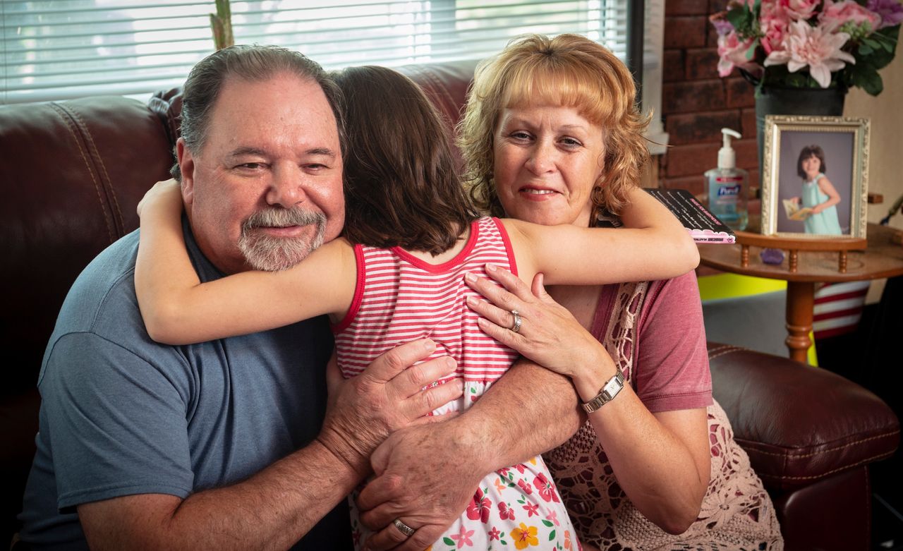 Tessa gives a spontaneous hug to her grandmother, Jodie Hicks, right, and her step-grandfather, Kevin O'Brien.