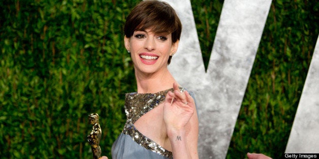 Anne Hathaway carrying her Oscar for best supporting actress arrives for the 2013 Vanity Fair Oscar Party on February 24, 2013 in Hollywood, California. AFP PHOTO / ADRIAN SANCHEZ-GONZALEZ (Photo credit should read ADRIAN SANCHEZ-GONZALEZ/AFP/Getty Images)