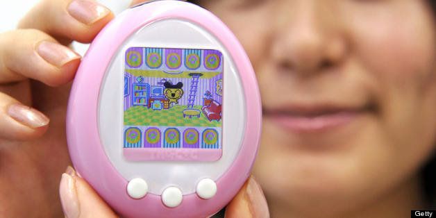 Japanese toy giant Bandai employee displays the new virtual pet toy with 1.52-inch color LCD display 'Tamagotchi plus color', mega-hit egg-shaped portable toy with cartoonlike characters at the company's headquarters in Tokyo on October 6, 2008. About 75 million Tamagotchi toys have been sold since they were launched in 1996. The new color Tamagotchi will go on sale in November. AFP PHOTO / Yoshikazu TSUNO (Photo credit should read YOSHIKAZU TSUNO/AFP/Getty Images)