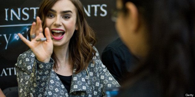 CHICAGO RIDGE, IL - JULY 30: Lily Collins signs autographs for fans in anticipation of Screen Gems' action-fantasy THE MORTAL INSTRUMENTS: CITY OF BONES at Chicago Ridge Mall on July 30, 2013 in Chicago Ridge, Illinois. (Photo by Timothy Hiatt/Getty Images for Sony Pictures Entertainment)