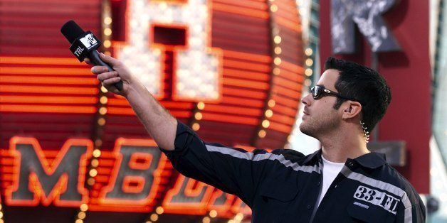 Host Carson Daly holds the microphone out while taping segments for MTV's 'Total Request Live' Spring Break show at the Fremont Street Experience March 11, 2000 in Las Vegas, Nevada. (Photo by Ethan Miller/Getty Images)