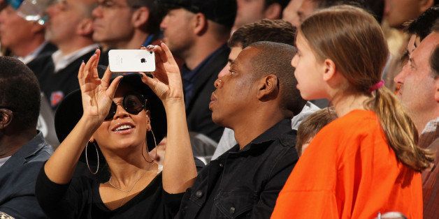 NEW YORK, NY - APRIL 15: Recording artist Beyonce Knowles takes a picture with her phone of husband Jay-Z as they attend the game between the Miami Heat and New York Knicks on April 15, 2012 at Madison Square Garden in New York City. NOTE TO USER: User expressly acknowledges and agrees that, by downloading and or using this photograph, User is consenting to the terms and conditions of the Getty Images License Agreement. Mandatory Copyright Notice: Copyright 2012 NBAE (Photo by Nathaniel S. Butler/NBAE via Getty Images)
