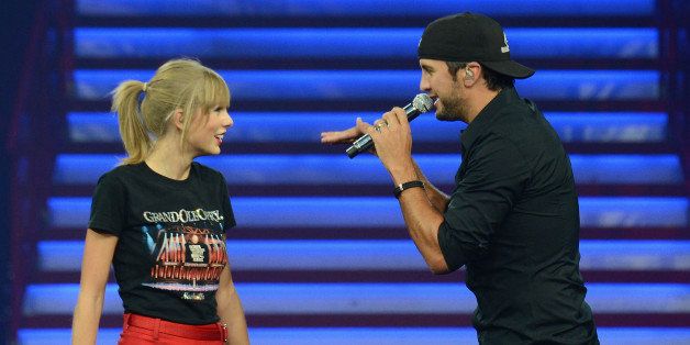 NASHVILLE, TN - SEPTEMBER 19: Taylor Swift wears a Grand Ole Opry t-shirt and is joined onstage by special guest Luke Bryan as she wraps the North American portion of her RED tour playing to a crowd of more than 14,000 fans on the first of three sold-out hometown shows at Nashville's Bridgestone Arena on September 19, 2013. (Photo by Larry Busacca/TAS/Getty Images for TAS)