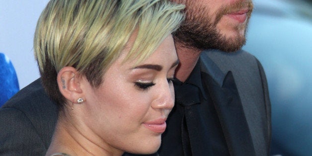 LOS ANGELES, CA - AUGUST 08: Actors Miley Cyrus (L) and Liam Hemsworth attend the premiere of Relativity Media's 'Paranoia'