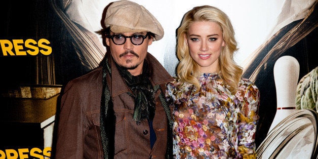 PARIS, FRANCE - NOVEMBER 08: Johnny Depp and Amber Heard pose during the 'Rhum Express' Photocall at Hotel Paris Plaza Athen