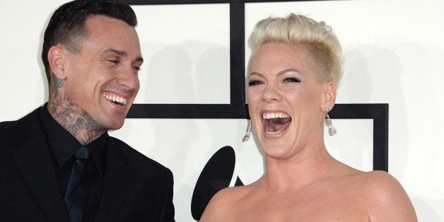 Motorcycle racer Carey Hart and singer Pink arrive on the red carpet for the 56th Grammy Awards at the Staples Center in Los Angeles, California, January 26, 2014. AFP PHOTO ROBYN BECK (Photo credit should read ROBYN BECK/AFP/Getty Images)