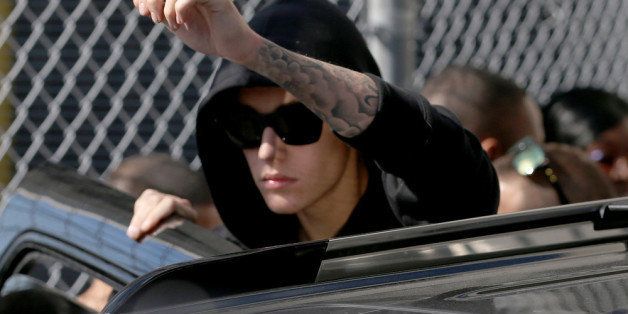MIAMI, FL - JANUARY 23: Justin Bieber prepares to stand on his vehicle after exiting from the Turner Guilford Knight Correctional Center on January 23, 2014 in Miami, Florida. Justin Bieber was charged with drunken driving, resisting arrest and driving without a valid license after Miami Beach police found the pop star street racing Thursday morning. (Photo by Joe Raedle/Getty Images)