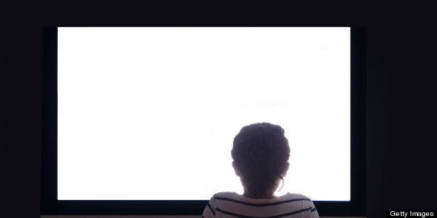 Girl sat on floor in front of large white screen