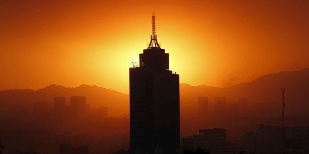 The sun sets behind the World Trade Center building in Mexico City March 14, 2016. Mexico City's government ordered traffic restrictions on Tuesday and recommended people stay indoors due to serious air pollution, issuing its second-highest alert warning for ozone levels for the first time in 13 years. REUTERS/Edgard Garrido TPX IMAGES OF THE DAY 