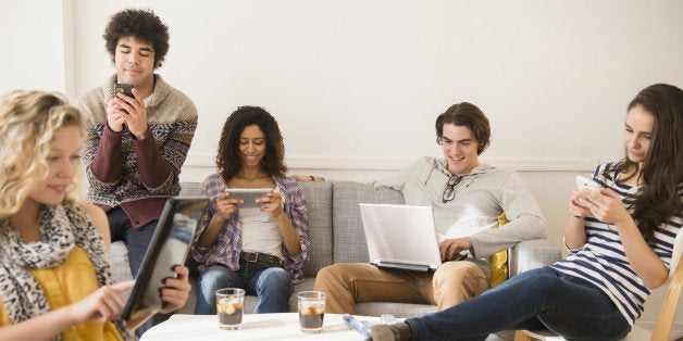 Friends using technology in living room