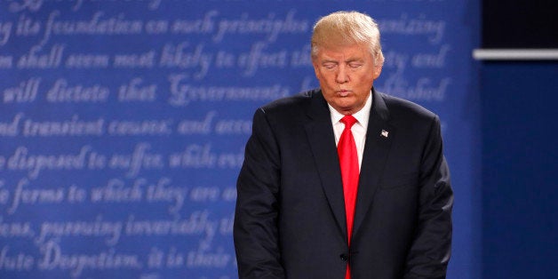 Republican U.S. presidential nominee Donald Trump listens as Democratic U.S. presidential nominee Hillary Clinton (not pictured) speaks during their presidential town hall debate at Washington University in St. Louis, Missouri, U.S., October 9, 2016. REUTERS/Lucy Nicholson