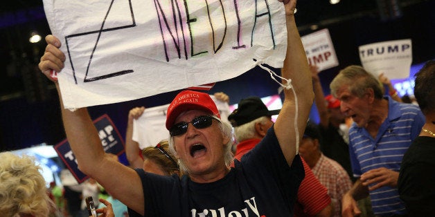 WEST PALM BEACH, FL - OCTOBER 13: A man holds a sign towards the media as he attends a campaign rally for Republican presidential candidate Donald Trump at the South Florida Fair Expo Center on October 13, 2016 in West Palm Beach, Florida. Trump continues to campaign against Democratic presidential candidate Hillary Clinton with less than one month to Election Day. (Photo by Joe Raedle/Getty Images)