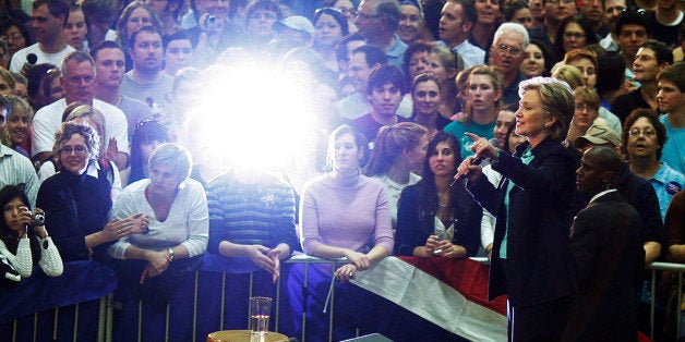 Democratic presidential candidate US Senator Hillary Clinton (D-NY) is lit by the flash from an audience member's camera at a