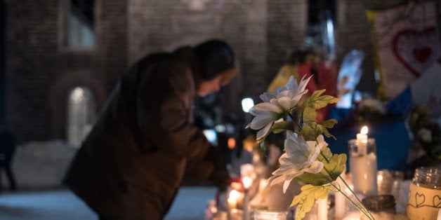 People place candles near a mosque that was the location of a shooting spree in Quebec City, Quebec on January 31, 2017.
Ale