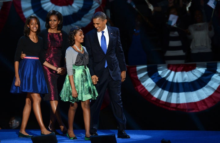 US President Barack Obama and family arrive on stage after winning the 2012 US presidential election November 7, 2012 in Chicago, Illinois. Obama swept to re-election, forging history again by defying the dragging economic recovery and high unemployment which haunted his first term to beat Republican Mitt Romney. AFP PHOTO / Saul LOEB (Photo credit should read SAUL LOEB/AFP/Getty Images)