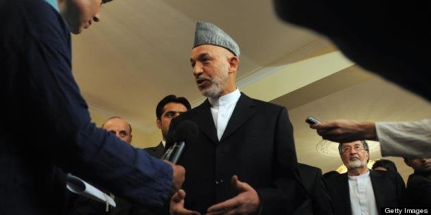 Afghan President Hamid Karzai speaks to journalists after a press conference at the Presidential Palace in Kabul on August 20, 2009. Karzai thanked Afghans for defying insurgent threats and voting in landmark elections, hailing a 'day of pride and glory' for the country. In a live television address as polling wound down, Karzai said there had been 73 incidents of violence in 15 provinces during the day, some of which had caused casualties to police and civilians. AFP PHOTO/MASSOUD HOSSAINI (Photo credit should read MASSOUD HOSSAINI/AFP/Getty Images)