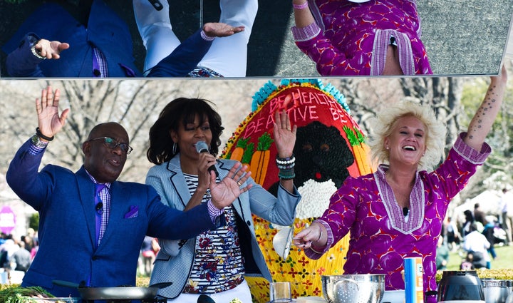 US First Lady Michelle Obama (C), chef Anne Burrell (R) and television personality Al Roker sing at a cooking station during