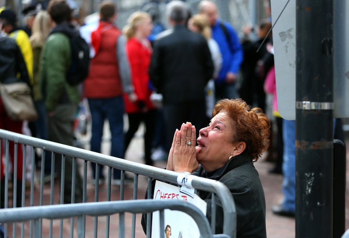 BOSTON - APRIL 15: A woman kneels and prays at the scene of the first explosion on Boylston Street near the finish line of the 117th Boston Marathon on April 15, 2013. (Photo by John Tlumacki/The Boston Globe via Getty Images)