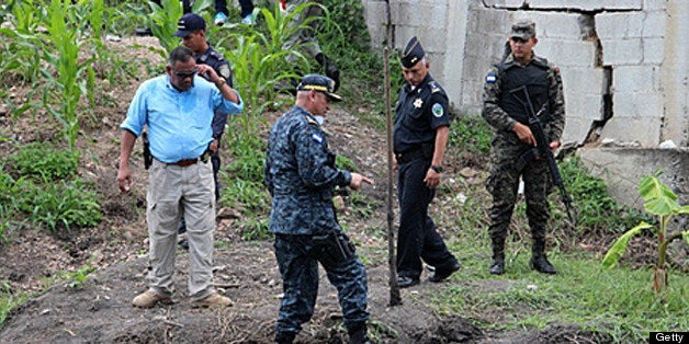 Honduran police director Juan Carlos 'El Tigre' Bonilla (C) works in the site where human remains allegedly corresponding to Honduran journalist Anibal Barrow were found on July 9, 2013 in a lagoon at Villanueva muicipality, Cortes department, 220 km north of Tegucigalpa. Government statistics indicate that at least 33 journalists have been assassinated in Honduras in the last four years. AFP PHOTO /STR (Photo credit should read STR/AFP/Getty Images)