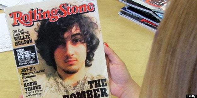 An early copy of Rolling Stone magazine's August 2013 issue is read at an office in Los Angeles on July 17, 2013. Rolling Stone defended the cover story on Boston bombing suspect Dzhokhar Tsarnaev, which triggered criticism that the magazine was 'glamorizing terrorism' and calls to boycott the publication. At least two national chain stores announced they would not be selling the latest issue of the magazine, known for interviews with rock stars and others. The cover picture -- showing a goateed Tsarnaev, 19, was likened to a famous Rolling Stone cover portrait of the late singer Jim Morrison of 'The Doors.' The accompanying Rolling Stones article, titled 'The Bomber,' was described by the magazine as a 'deeply reported account of the life and times' of Tsarnaev. The 12-page story is based on interviews with dozens of sources that 'deliver a riveting and heartbreaking account of how a charming kid with a bright future became a monster,' it said. AFP PHOTO/Michael THURSTON (Photo credit should read Michael THURSTON/AFP/Getty Images)