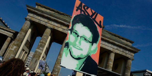 Demonstrators hold up a placard in support of former US agent of the National Security Agency, Edward Snowden in front of Berlin's landmark Brandenburg Gate as they take part in a protest against the US National Security Agency (NSA) collecting German emails, online chats and phone calls and sharing some of it with the country's intelligence services in Berlin on July 27, 2013. AFP PHOTO / JOHN MACDOUGALL (Photo credit should read JOHN MACDOUGALL/AFP/Getty Images)
