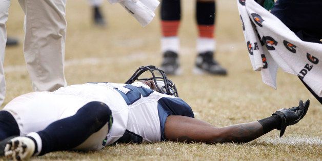 CHICAGO, IL - JANUARY 16: Marcus Trufant #23 of the Seattle Seahawks lays on the ground after suffering a concussion against the Chicago Bears during the NFC Divisional playoff game at Soldier Field on January 16, 2011 in Chicago, Illinois. The Bears defeated the Seahawks 35-24. (Photo by Joe Robbins/Getty Images)