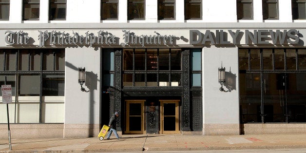 UNITED STATES - JANUARY 03: A Philadelphia Inquirer newspaper vendor walks past the Broad Street headquarters housing the editorial and corporate offices of the Inquirer and Daily News in Philadelphia, Pennsylvania, Wednesday, January 3, 2007, . The Philadelphia Inquirer yesterday eliminated 68 jobs, or 17 percent of its newsroom staff, as the newspaper's new owners struggle with advertising and circulation declines. (Photo by Bradley C. Bower/Bloomberg via Getty Images)