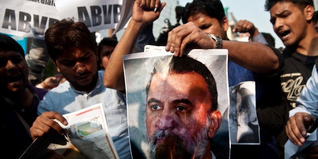 Activists of Akhil Bharatiya Vidya Parishad (ABVP) burn a photograph of Tarun Tejpal, founder and editor of Tehelka magazine, outside the magazine's office in New Delhi on November 22, 2013. The editor of India's leading investigative news magazine was accused of trivialising a serious sex crime after he announced he would take six months' leave as 'penance' for assaulting a female colleague. AFP PHOTO/MANAN VATSYAYANA (Photo credit should read MANAN VATSYAYANA/AFP/Getty Images)