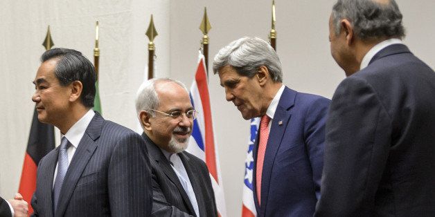 Iranian Foreign Minister Mohammad Javad Zarif (2nd L) shakes hands with US Secretary of State John Kerry next to Chinese Foreign Minister Wang Yi (far L) and French Foreign Minister Laurent Fabius (far R) after a statement on early November 24, 2013 in Geneva. World powers on November 24 agreed a landmark deal with Iran halting parts of its nuclear programme in what US President Barack Obama called 'an important first step'. According to details of the accord agreed in Geneva provided by the White House, Iran has committed to halt uranium enrichment above purities of five percent. AFP PHOTO / FABRICE COFFRINI (Photo credit should read FABRICE COFFRINI/AFP/Getty Images)