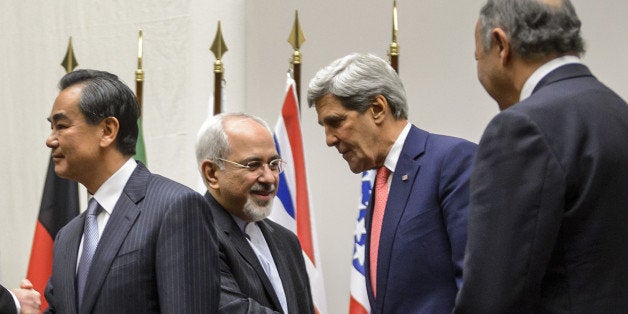 Iranian Foreign Minister Mohammad Javad Zarif (2nd L) shakes hands with US Secretary of State John Kerry next to Chinese Fore