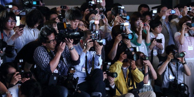 Photographers work during the unveiling of NTT DoCoMo Inc.'s new smartphones in Tokyo, Japan, on Wednesday, May 15, 2013. NTT DoCoMo is Japan's biggest mobile-phone company. Photographer: Tomohiro Ohsumi/Bloomberg via Getty Images