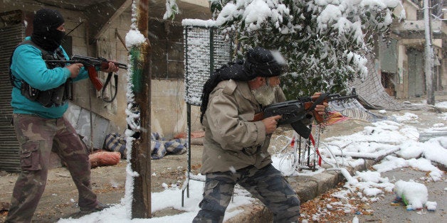 Rebel fighters hold their weapons as they stand amidst snow during clashes with Syrian pro-government forces in the Salaheddi