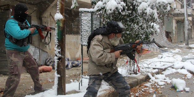 Rebel fighters hold their weapons as they stand amidst snow during clashes with Syrian pro-government forces in the Salaheddin neighbourhood of Syria's northern city of Aleppo on December 11, 2013. Gulf Arab states called for the withdrawal of 'all foreign forces' from Syria, where Iran-backed Shiite militias from Iraq and Lebanon are supporting regime troops against mostly-Sunni rebels. AFP PHOTO/MEDO HALAB (Photo credit should read MEDO HALAB/AFP/Getty Images)