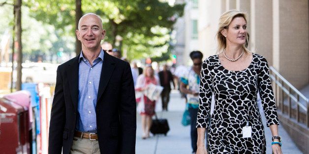 Jeff Bezos, founder and chief executive officer of Amazon Inc. and new owner of The Washington Post, left, leaves from the newspaper's offices with Katharine Weymouth, publisher of the Washington Post, after a meeting in Washington, D.C., U.S., on Wednesday, Sept. 4, 2013. Bezos agreed last month to buy the Washington Post for $250 million in a bet that he can apply his success in e-commerce to the struggling newspaper industry. Photographer: T.J. Kirkpatrick/Bloomberg via Getty Images 