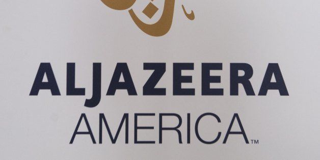 The logo for the cable news network Al Jazeera America appears outside the network's studio space at the Newseum in Washington, DC, August 16, 2013. Al Jazeera America, a cable news network set to launch on August 20, will have 12 bureaus in major cities in the US, three broadcast centers, a headquarters in New York City, and around 900 journalists and staff. AFP PHOTO / Saul LOEB (Photo credit should read SAUL LOEB/AFP/Getty Images)