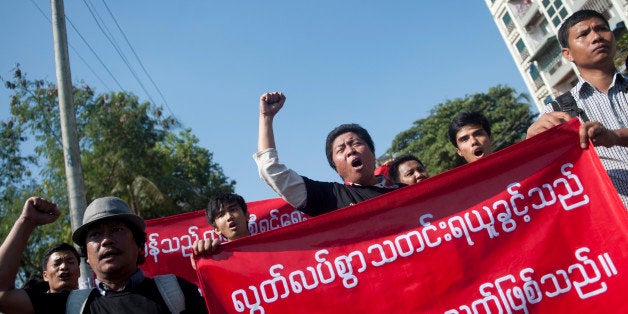 Reporters hold banners and shout slogans as they attend a demonstration march for press freedom in Yangon on January 7, 2014. Privately owned daily newspapers hit Myanmar's streets on April 1, 2013 for the first time in decades under new freedoms that represent a revolution for a media industry which was shackled under military rule. Observers at the time hoped that a new media law being drafted by an interim press council will define the limits of press freedoms and replace harsh junta-imposed legislation. But authorities revealed they had written their own proposal, stoking fears that government is unwilling fully to relinquish control. AFP PHOTO / YE AUNG THU (Photo credit should read Ye Aung Thu/AFP/Getty Images)