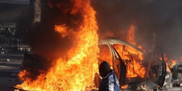 KIEV, UKRAINE - FEBRUARY 18: A car is engulfed in flames during a mass action of opposition at Independence Square aimed at forcing president Viktor Yanukovych to resign on February 18, 2014 in Kiev, Ukraine. Mass protest actions started after the president of Ukraine Victor Yanukovych refused the association agreement with the European Union. (Photo by Kirill Chubotin/Kommersant Photo via Getty Images)