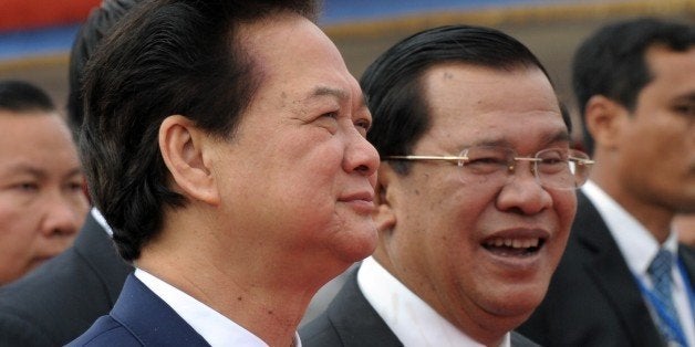 Vietnamese Prime Minister Nguyen Tan Dung (L) walks with Cambodian Prime Minister Hun Sen (R) during the official inauguratio