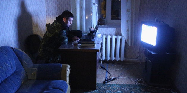 LUBIMOVKA, UKRAINE - MARCH 04: A Ukrainian soldier inside the Belbek military base watches a television newscast in the very