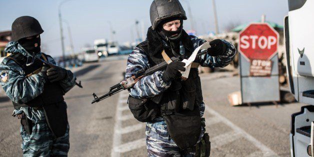 A pro-Russian serviceman checks a driver's documents at Chongar checkpoint blocking the entrance to Crimea on March 10, 2014. Russia vowed on March 10 to unveil its own solution to the Ukrainian crisis that would run counter to US efforts and would appear to leave room for Crimea to switch over to Kremlin rule. The unexpected announcement came as Ukraine's new pro-European leaders raced to rally Western support in the face of the seizure by Kremlin-backed forces of the strategic Black Sea peninsula and plans to hold a Sunday referendum on switching Crimea's allegiance from Kiev to Moscow. AFP PHOTO/ ALISA BOROVIKOVA (Photo credit should read ALISA BOROVIKOVA/AFP/Getty Images)