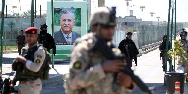 Iraqi soldiers stand guard next to a portrait of the Iraqi President at a checkpoint outside the presidential compound as they replace Kurdish peshmerga guards on March 23, 2014 following the killing of a journalist by one of the guards. A presidential guard shot dead a senior Iraqi journalist during an argument yesterday and then fled, briefly sparking a standoff in which Prime Minister Nuri al-Maliki demanded he be handed over. AFP PHOTO / AHMAD AL-RUBAYE (Photo credit should read AHMAD AL-RUBAYE/AFP/Getty Images)