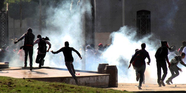 CAIRO, EGYPT - MARCH 26: Activists gather in front of the Cairo University to protest the criminal court in Minya, condemned 528 Morsi supporters to death on March 26, 2014 in the capital Cairo, Egypt. Egyptian riot police intervene the demonstrator with tear gas during the protests. (Photo by Ahmed Taranh/Anadolu Agency/Getty Images)