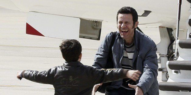 El Mundo correspondent Javier Espinosa is greeted by his son as he arrives at the military airbase in Torrejon de Ardoz, near Madrid, on March 30, 2014. Two Spanish journalists taken hostage in Syria by an Al-Qaeda-linked group walked free after six months in captivity and were heading back to Spain today, their friends and colleagues said. Espinosa and Vilanova were seized on September 16 as they tried to cross the Syrian border to Turkey, the latest of scores of journalists captured while covering Syria's civil war. AFP PHOTO / POOL / PACO CAMPOS (Photo credit should read PACO CAMPOS/AFP/Getty Images)