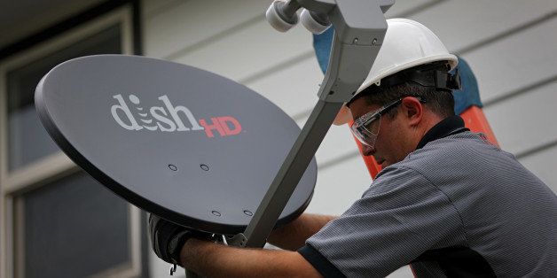 Justin Preziosi, field service specialist for Dish Network Corp., installs a satellite television system at a residence in Denver, Colorado, U.S., on Tuesday, Aug. 6, 2013. Dish Network Corp., the third-largest U.S. pay-TV company by customers, and Charter Communications Inc., the eighth-biggest, both may look to combine with competitors as a way to gain leverage in negotiations with TV networks to carry their programming. Photographer: Matthew Staver/Bloomberg via Getty Images 
