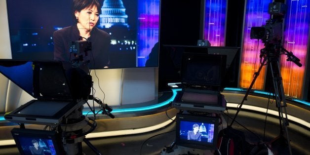 Joie Chen, host of the new Al Jazeera America nightly news program America Tonight, appears on television monitors in the network's studio space at the Newseum in Washington, DC, August 16, 2013. Al Jazeera America, a cable news network set to launch on August 20, will have 12 bureaus in major cities in the US, three broadcast centers, a headquarters in New York City, and around 900 journalists and staff. AFP PHOTO / Saul LOEB (Photo credit should read SAUL LOEB/AFP/Getty Images)