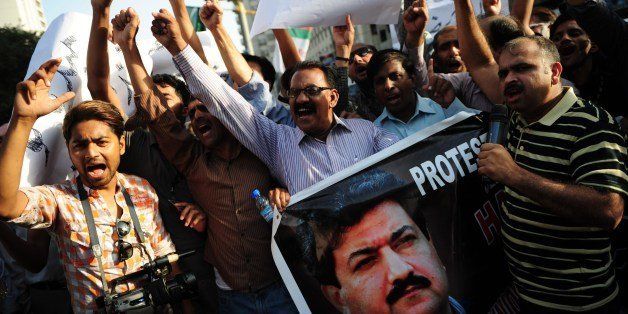 Pakistani journalist shout slogans during a protest against an attack on television anchor Hamid Mir in Karachi on April 21, 2014. A leading Pakistani journalist and TV anchor who was shot three times in an attack in Karachi is conscious and in stable condition, a spokesman from the hospital where he is being treated said. Hamid Mir, who hosts a prime-time current affairs talk show on the Geo News channel, was attacked while travelling by car to his office from the airport in Karachi. AFP PHOTO/Asif HASSAN (Photo credit should read ASIF HASSAN/AFP/Getty Images)