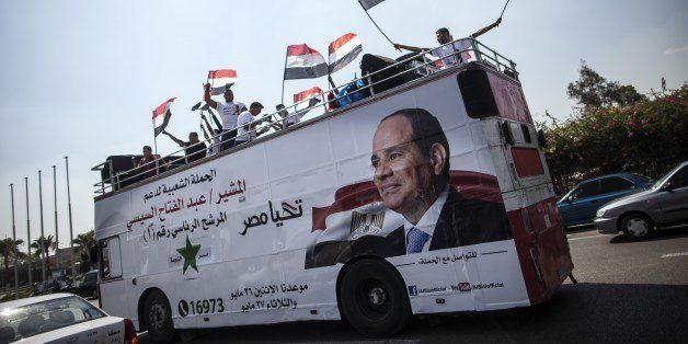 Supporters of Egyptian ex-army chief and leading presidential candidate Abdel Fattah al-Sisi wave national flags from the top of a bus covered with a giant portrait of him during a rally in his support on May 23, 2014 in the capital Cairo, few days the nation goes to the poles. Sisi is so sure of victory in the May 26-27 election that he has not addressed any public rallies in person or even revealed his election program. AFP PHOTO / MAHMOUD KHALED (Photo credit should read MAHMOUD KHALED/AFP/Getty Images)